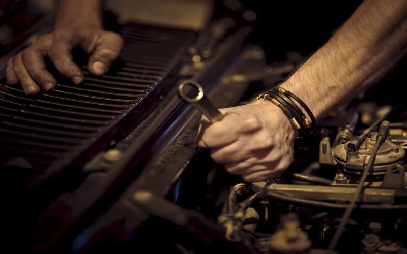 Auto mechanic inspecting a vehicle engine in a professional repair shop